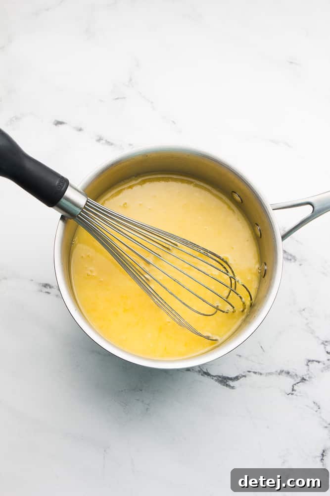 pan of yellow mixture with whisk in it