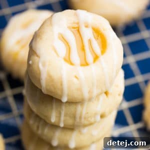 square image of lemon shortbread cookies stacked up on top of a blue towel
