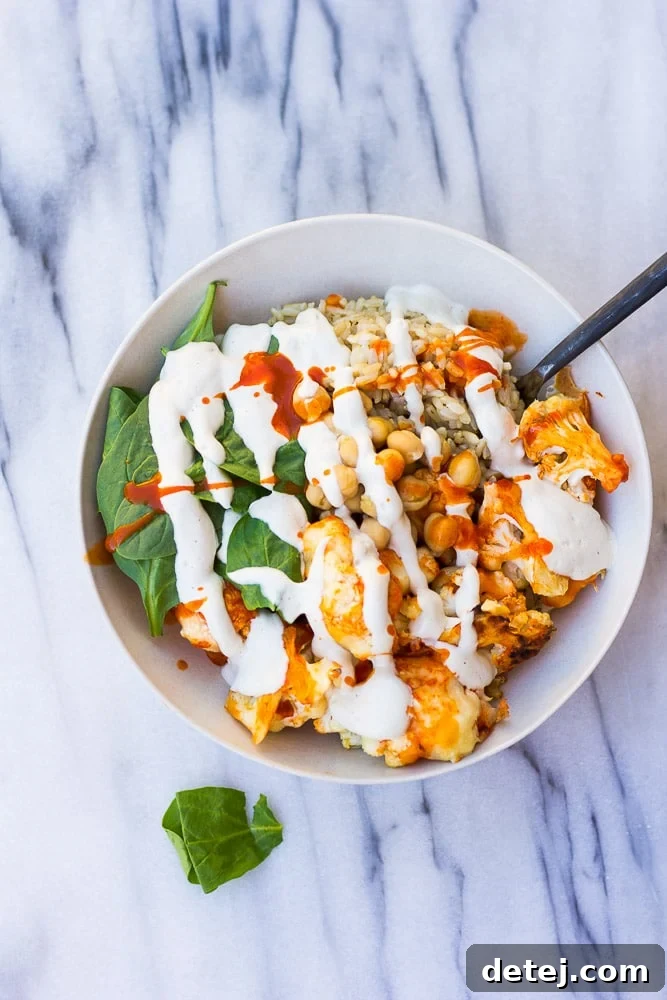Fiery Cauliflower Harvest Bowl 2 Buffalo Cauliflower Buddha Bowl with perfectly roasted cauliflower, brown rice, fresh spinach, chickpeas, and a generous topping of cashew cream.