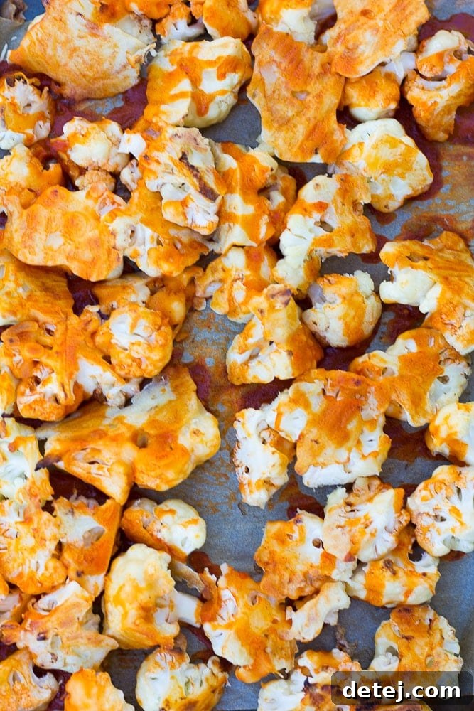 Fiery Cauliflower Harvest Bowl 3 Close-up shot of a Buffalo Cauliflower Buddha Bowl, highlighting the crispy roasted buffalo cauliflower, fluffy brown rice, vibrant green spinach, and creamy cashew dressing.