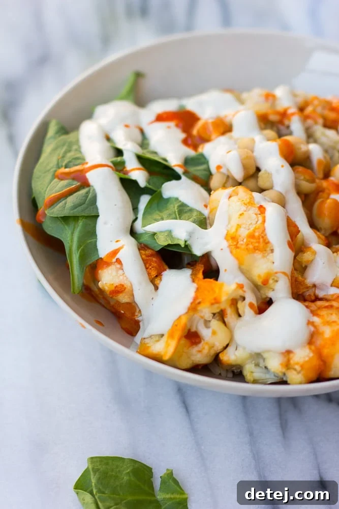 Fiery Cauliflower Harvest Bowl 4 A vibrant and healthy Buffalo Cauliflower Buddha Bowl, featuring roasted buffalo cauliflower, fluffy grains, chickpeas, fresh spinach, and a creamy cashew dressing, ready to be enjoyed.