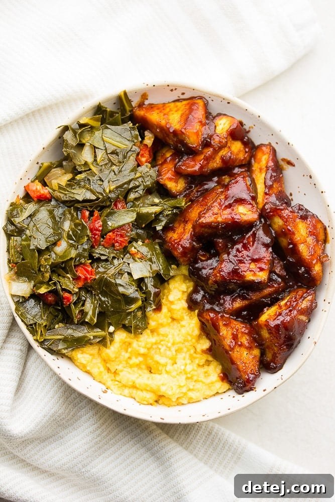 A vibrant Southern Soul Bowl featuring crispy BBQ tofu, creamy vegan cheese grits, and tender collard greens, showcasing the versatility of the tofu.
