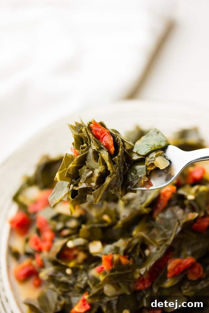 Smoky Vegan Collard Greens 5 fork holding cooked greens and tomatoes