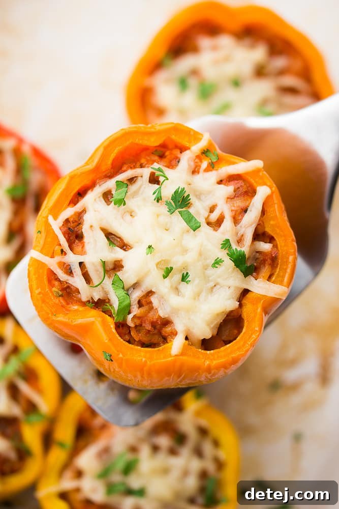 spatula holding a cooked bell pepper with stuffing in it