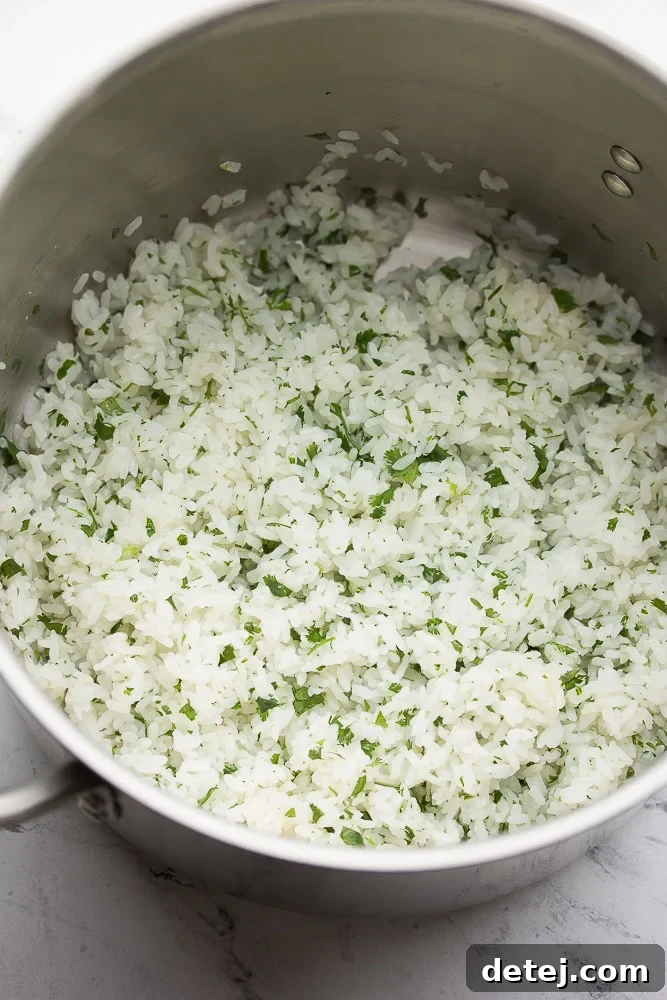 Fluffy, fragrant cilantro lime rice steaming gently in a medium pot, ready to be fluffed.