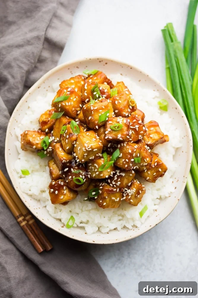 bowl with white rice and tofu with sauce and sesame seeds