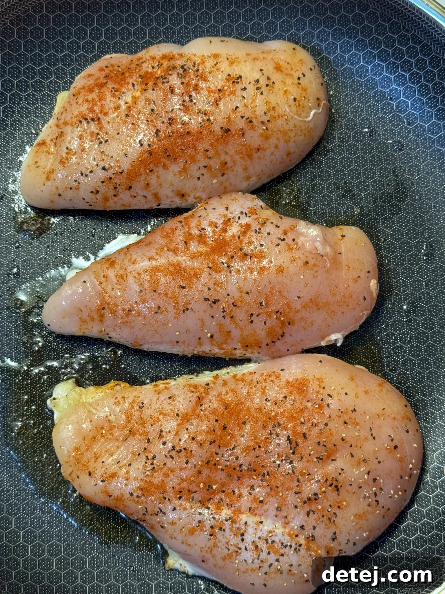 Fresh ingredients for Alice Springs Chicken including chicken breasts, bacon, cheese, and honey mustard sauce components, laid out on a wooden board.