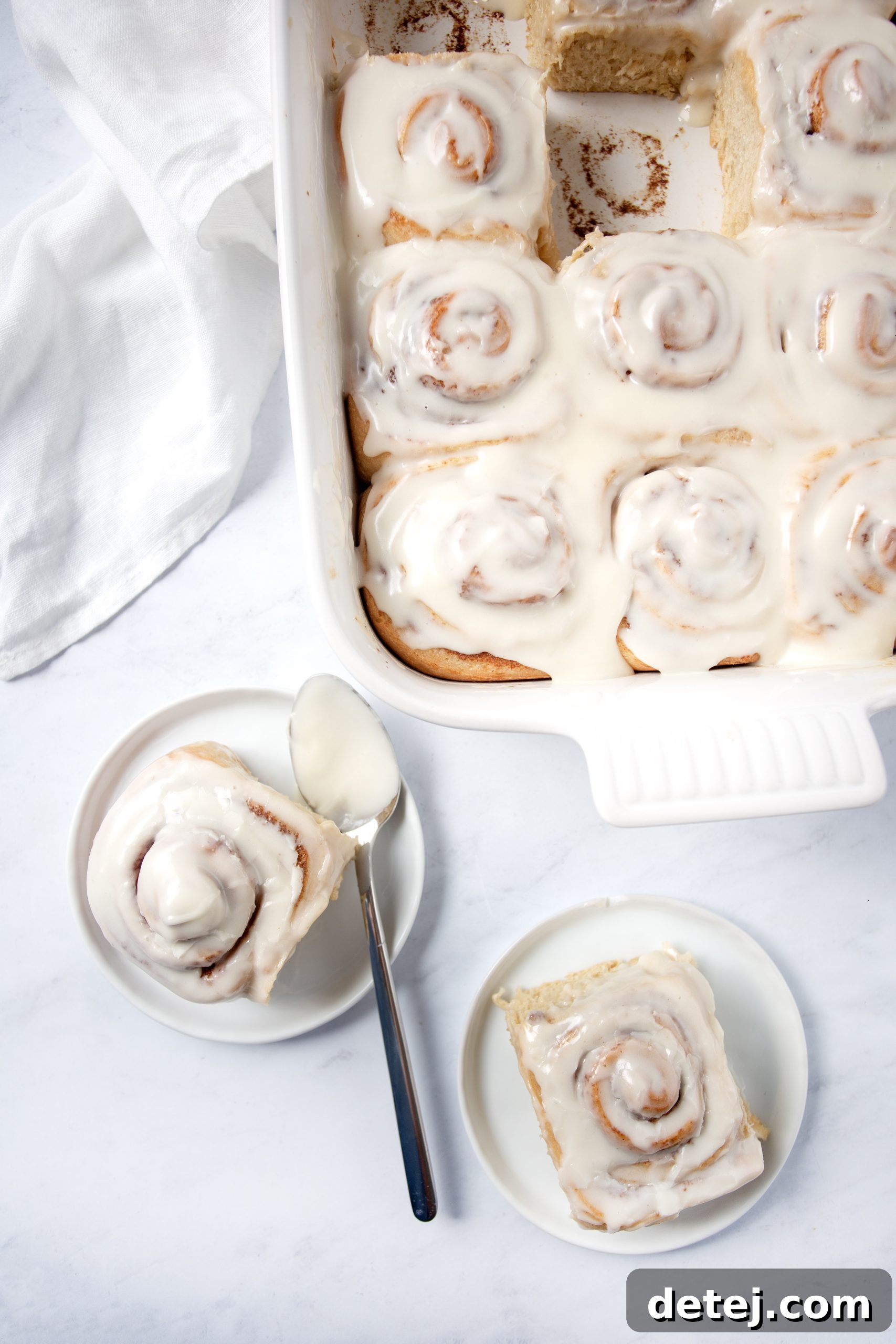 Stack of cinnamon rolls with cream cheese frosting, ready to serve