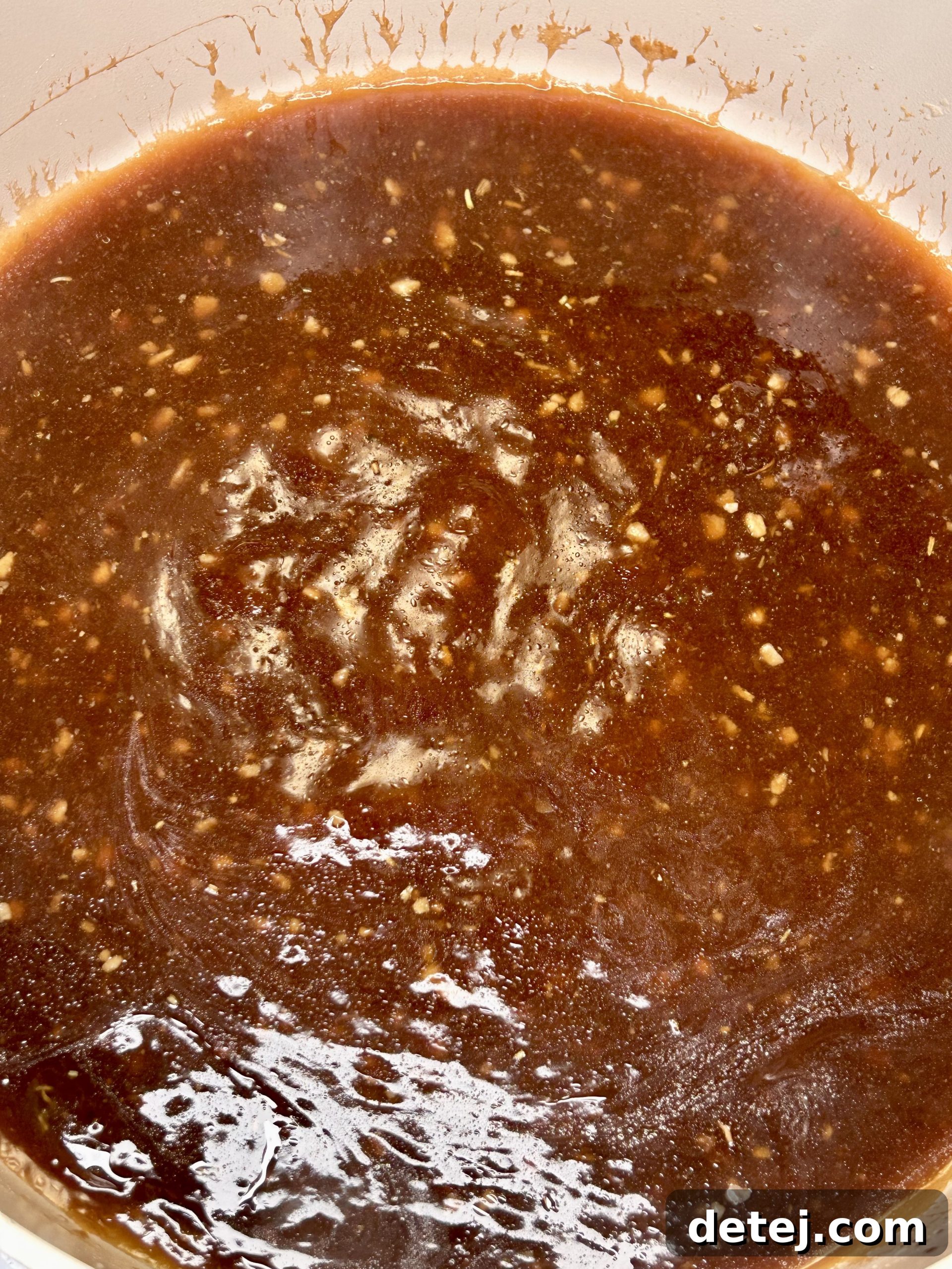 Velvety, dark gravy being stirred in a skillet, ready for beef tips.