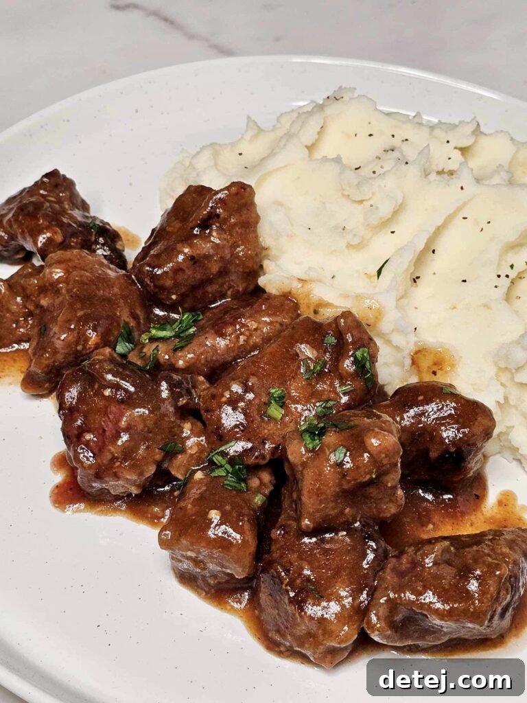 Beef Tips and Gravy served on a white plate with a fork.