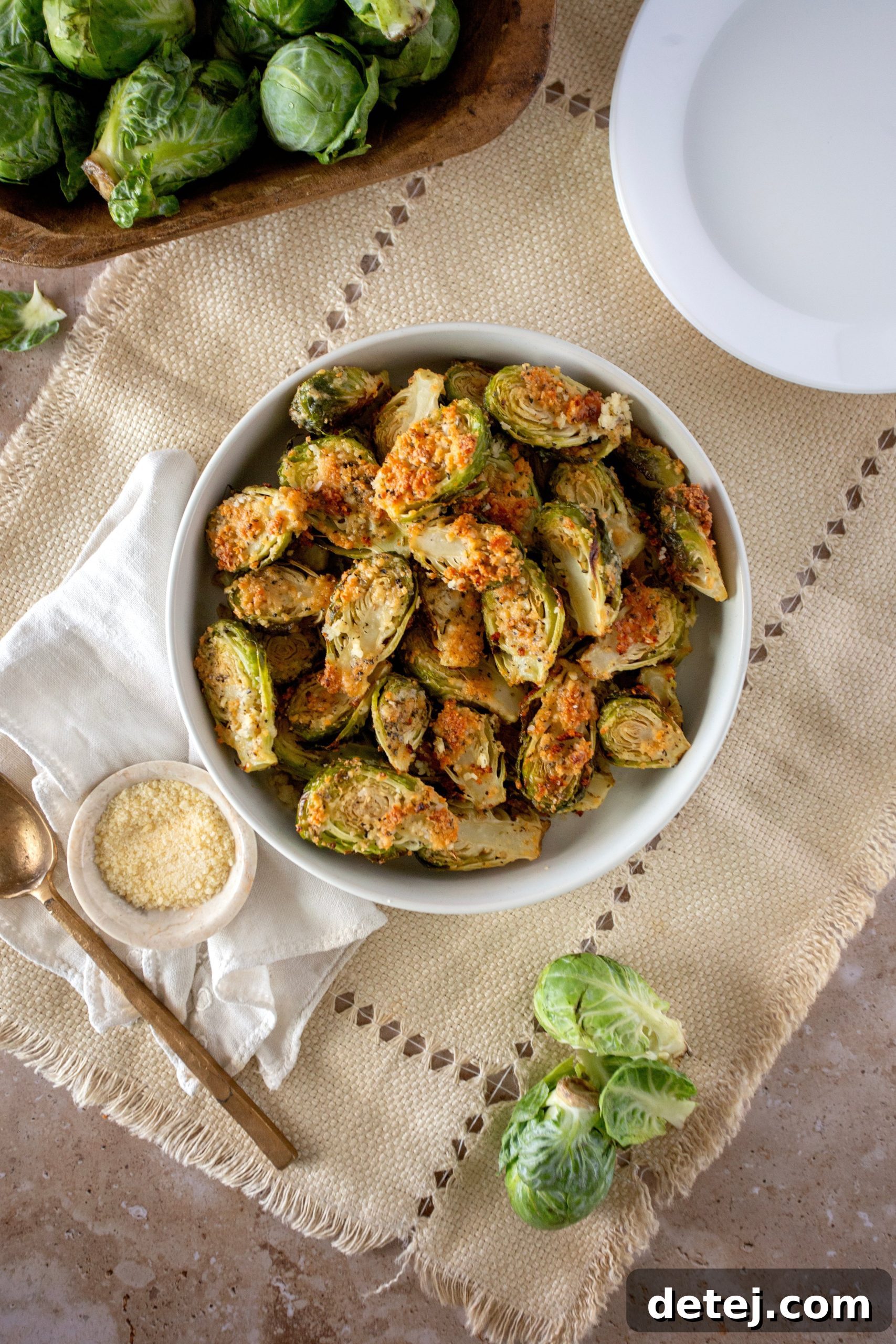 Parmesan Crusted Brussels Sprouts served on a rustic wooden board with a sprinkle of fresh herbs
