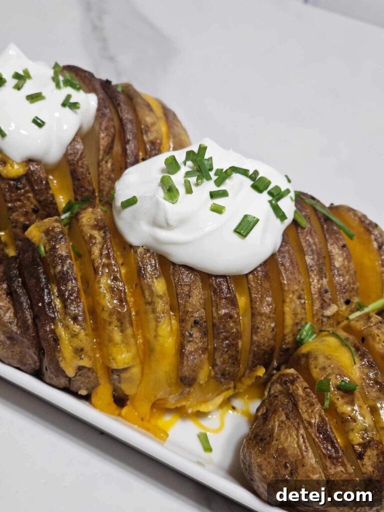 Beautifully plated Cheesy Hassleback Potatoes with garnishes