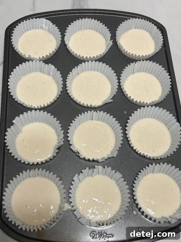 Freshly baked white cupcakes, ready for frosting.