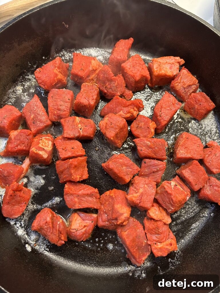 Steak bites searing in a cast iron skillet