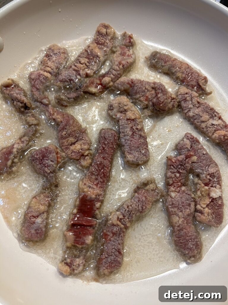 Crispy beef strips frying in hot oil