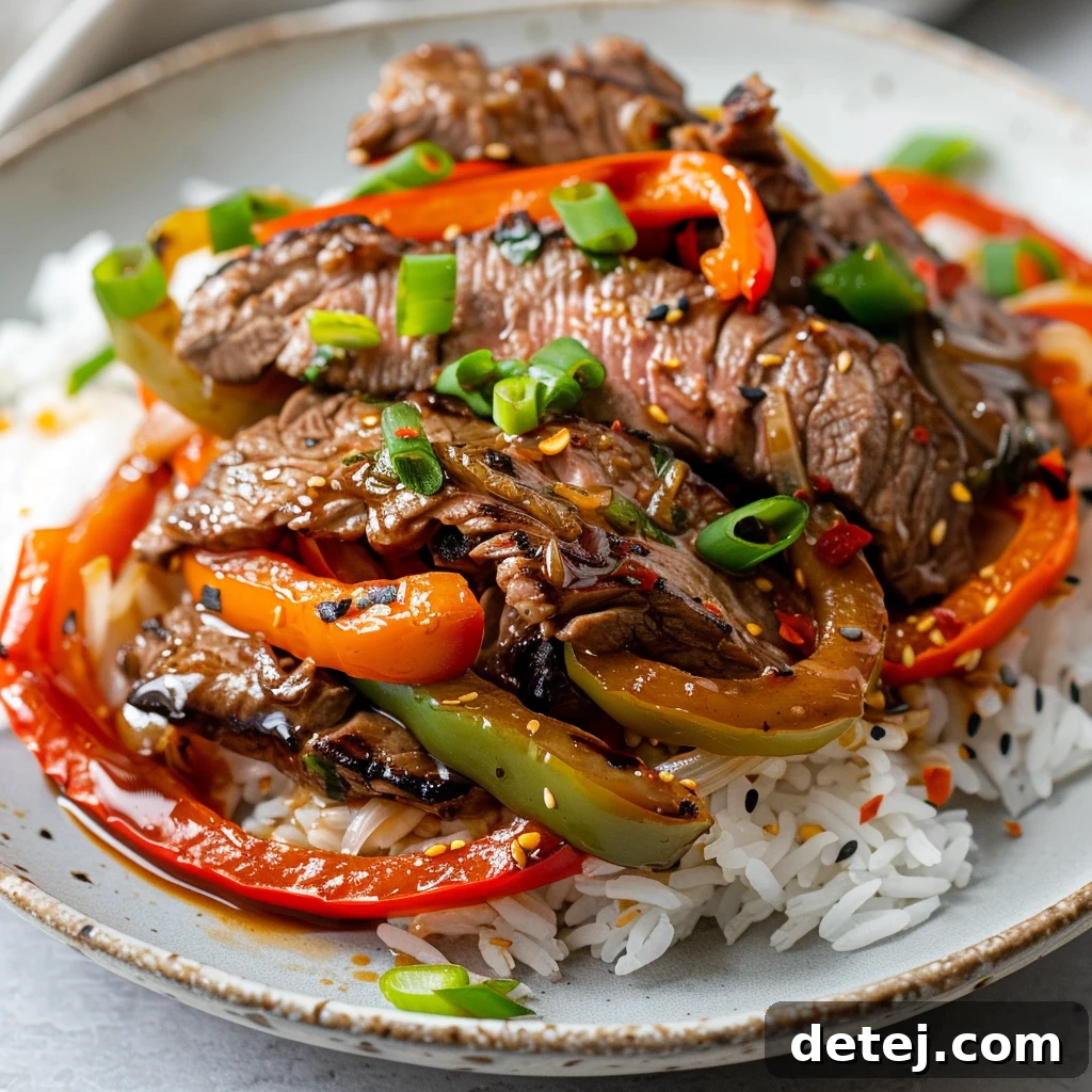 A vibrant Caribbean Pepper Steak simmering with bell peppers and a rich sauce in a skillet.