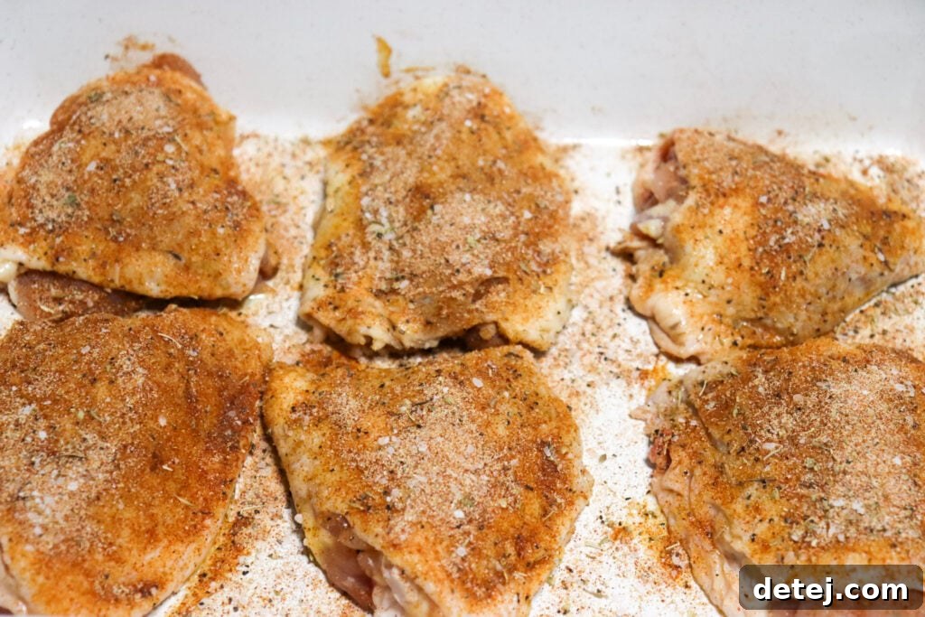 Effortless Golden Baked Chicken Thighs 4 Easy Oven Baked Chicken Thighs being seasoned