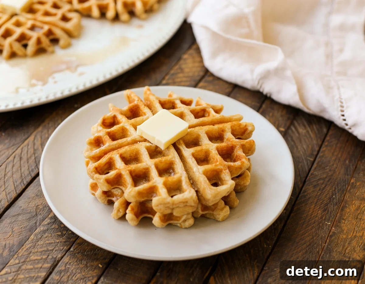Close-up of fresh ingredients for cinnamon bun waffles including flour, eggs, butter, and spices.