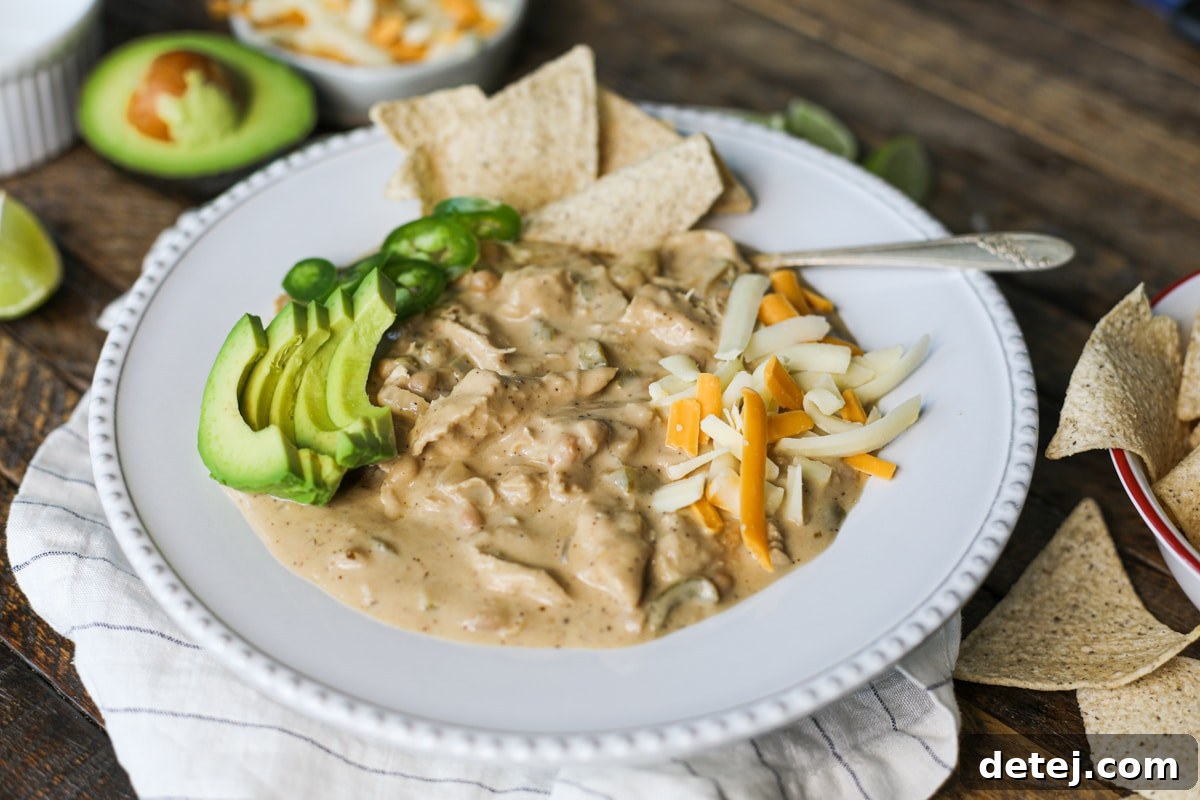 A large bowl of creamy white chicken chili, garnished with fresh cilantro and a dollop of sour cream, ready to be enjoyed.