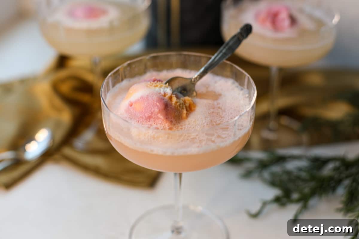 Close-up of Rainbow Sorbet Mimosa with effervescent bubbles and a mini spoon, highlighting the drink's vibrant appeal.