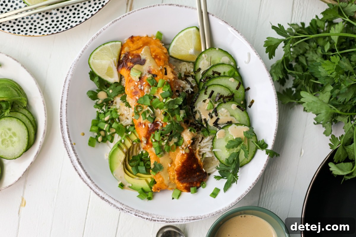 Close-up of baked salmon with creamy sauce, ready to be flaked into a bowl.