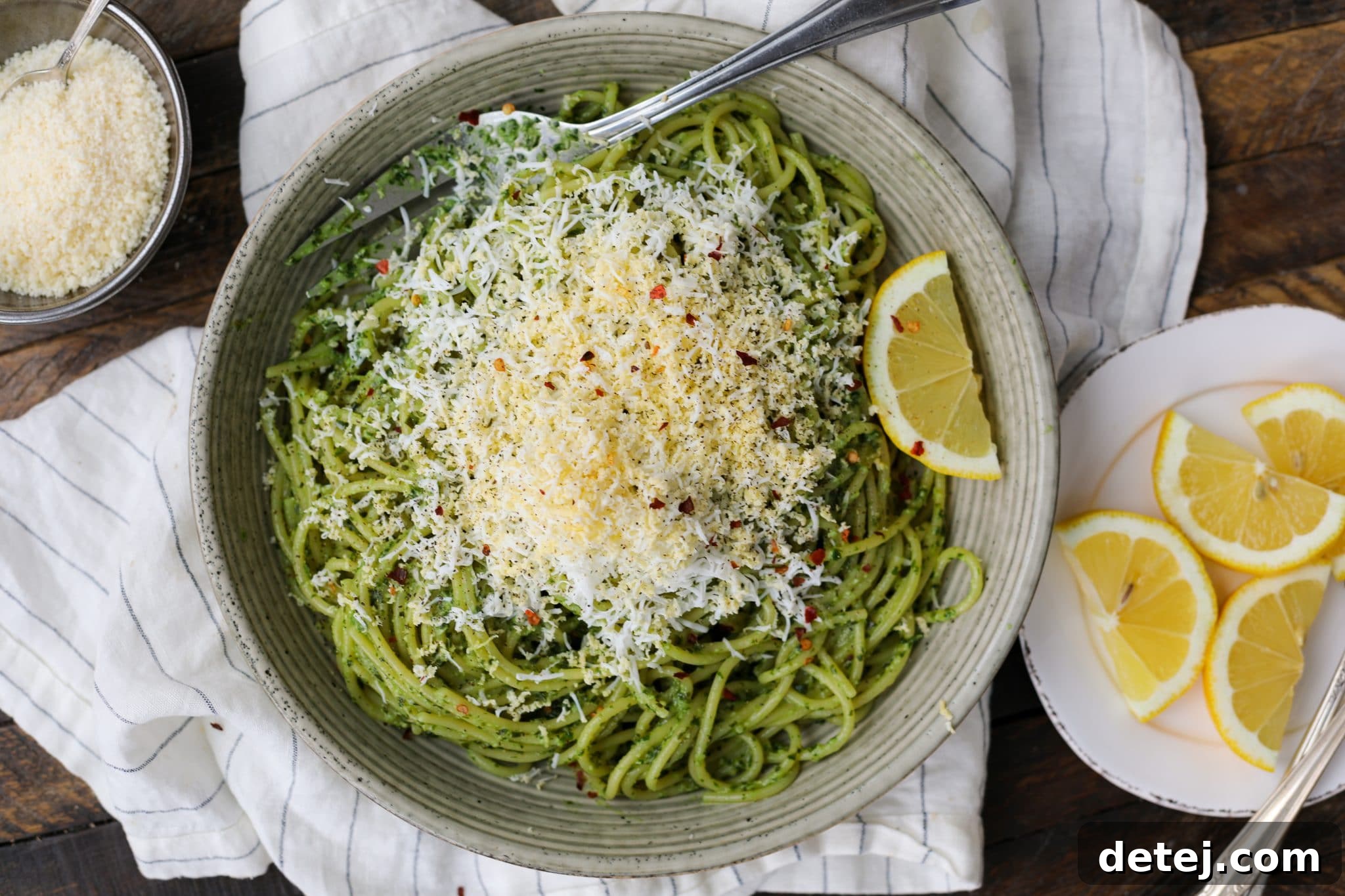 Close-up of freshly grated hard-boiled egg on pesto pasta. Healthyish Foods.