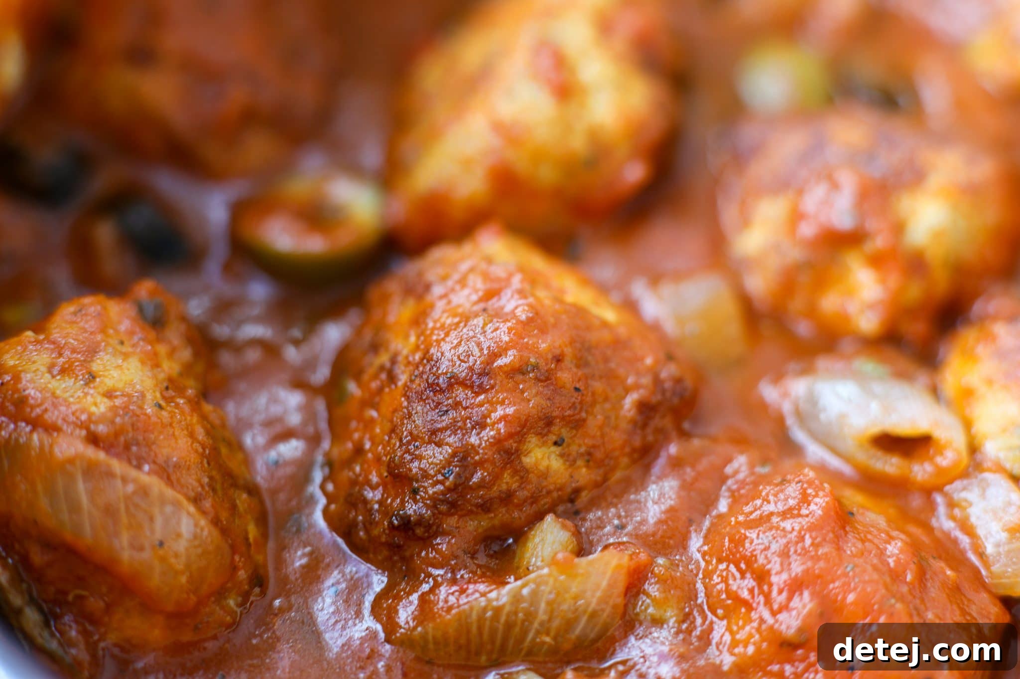 Close-up shot of pan-fried Chicken Cacciatore Meatballs simmering in a rich, rustic tomato sauce before serving. A healthy and quick dinner recipe.