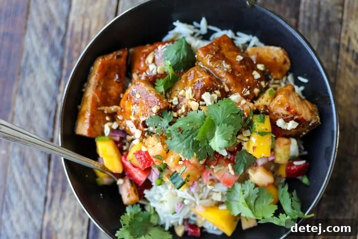 Crispy Teriyaki Salmon with a colorful side of Fresh Fruit Salsa, served in a bowl with rice.