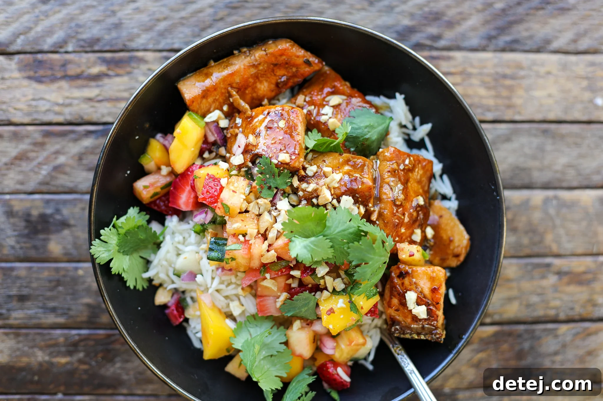 Teriyaki Salmon and Fruit Salsa bowls with rice, ready to eat.