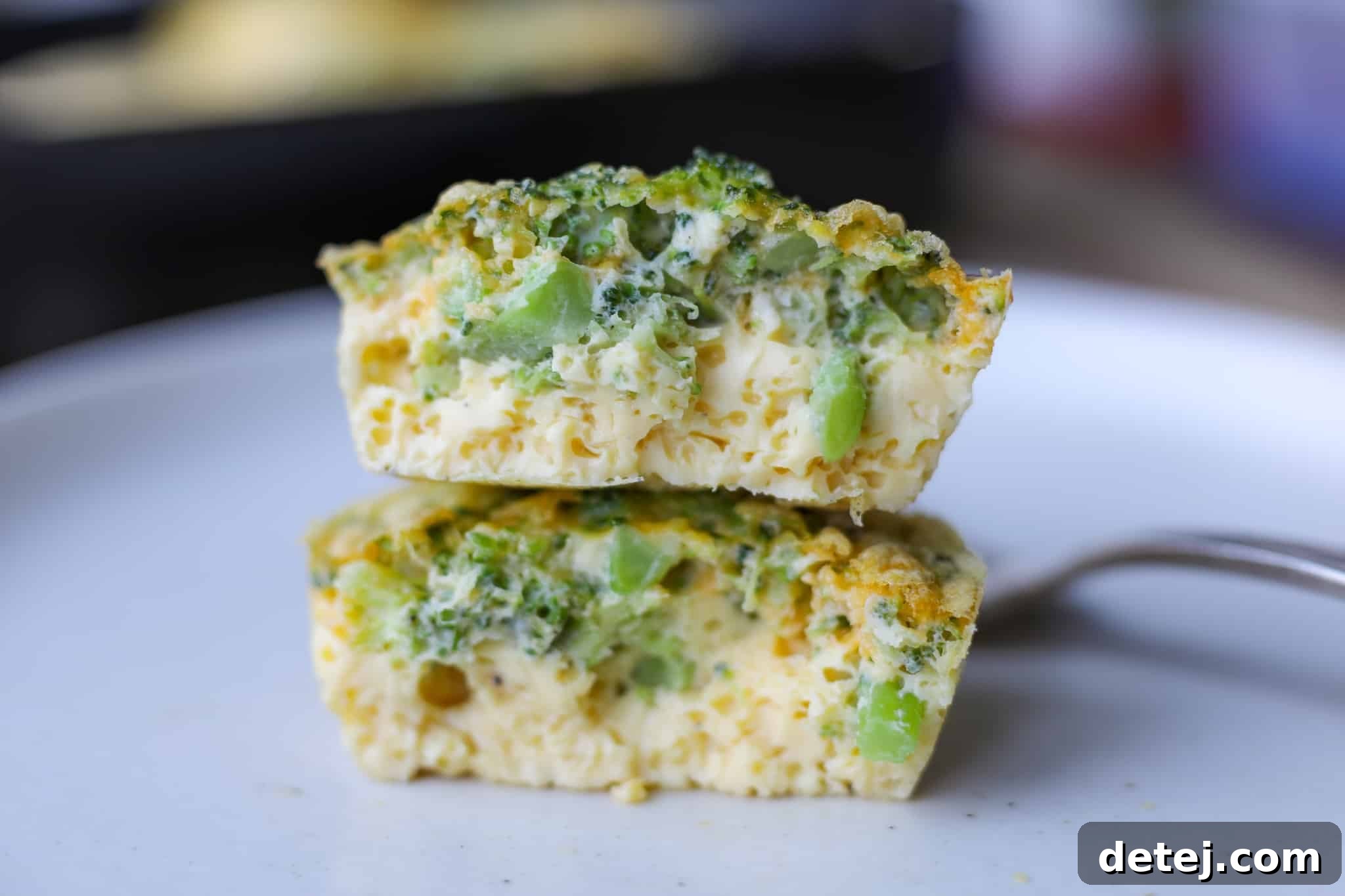 Two Broccoli Cheddar Blender Egg Bites on a plate, showcasing their creamy texture and delicious appeal.