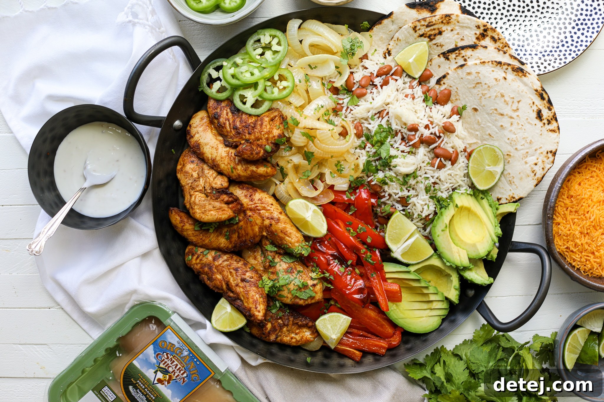 Close-up of roasted chicken and bell peppers, a key component of family-style fajitas, arranged on a baking sheet.