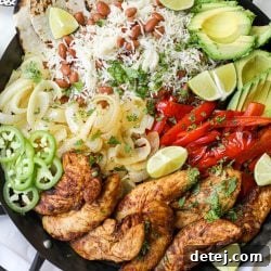 A vibrant close-up of Family Style Chicken Fajitas with roasted chicken, bell peppers, and onions, ready to be served.