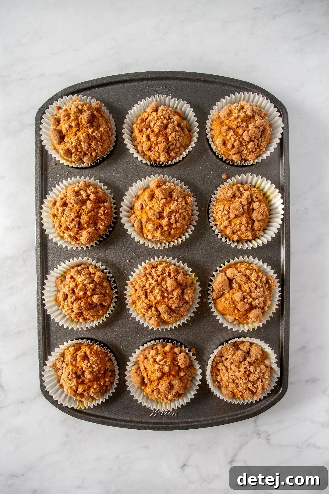 Close-up of golden pumpkin streusel muffins with a rich crumb topping.