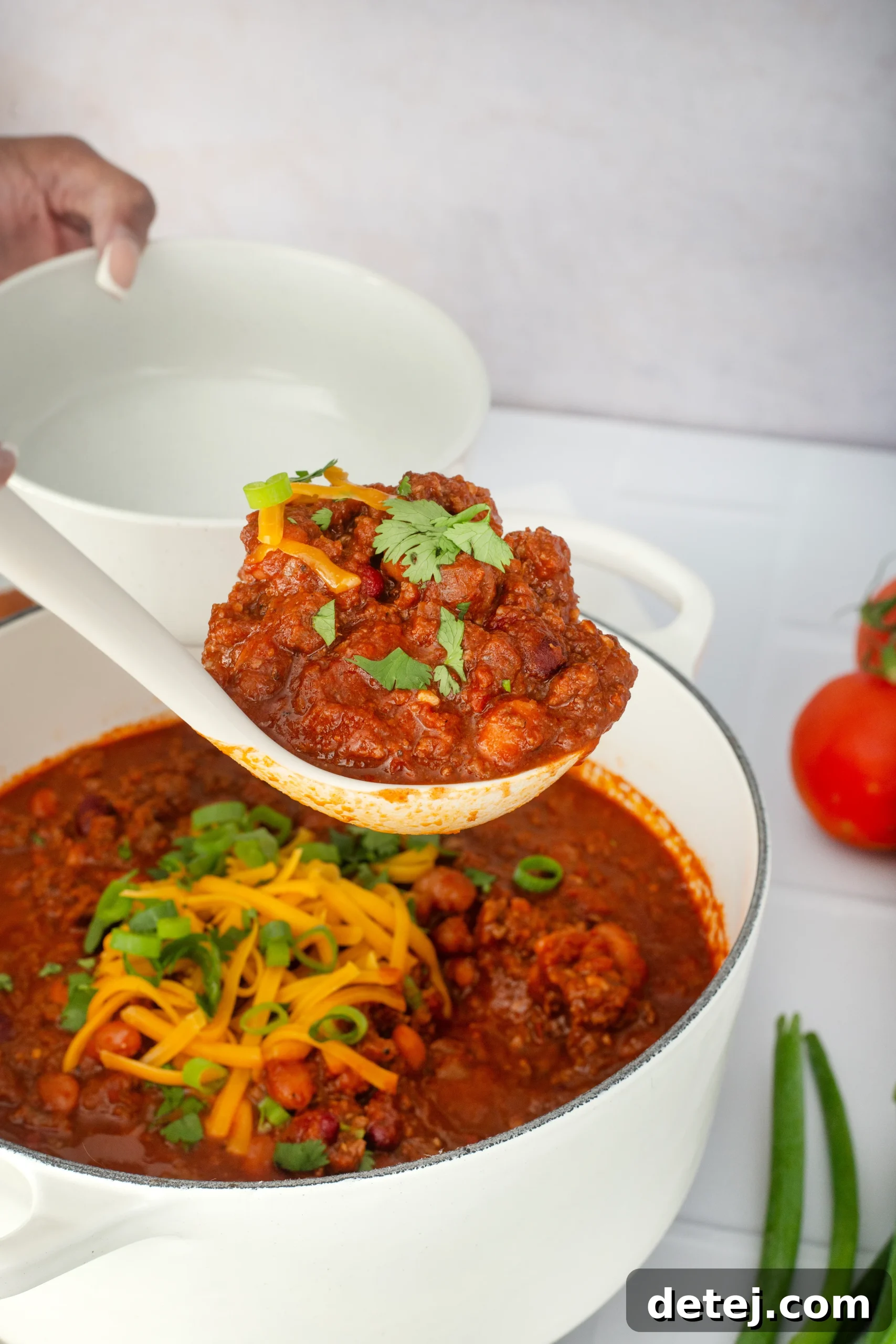 Lean ground beef browning perfectly in a large, heavy-bottomed Dutch oven on the stovetop, forming the flavorful base for chili.