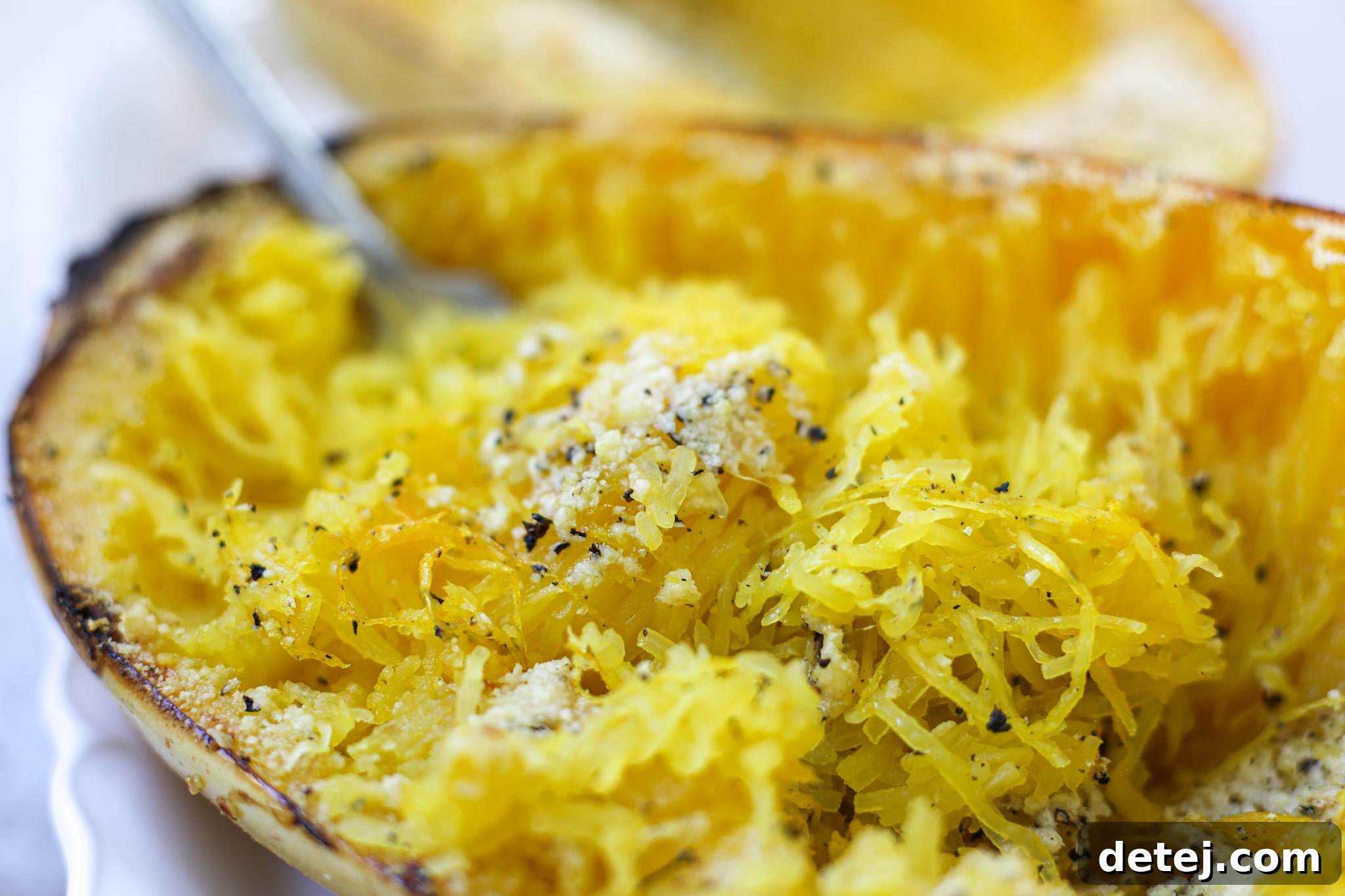 Close-up of Cacio e Pepe Roasted Spaghetti Squash, highlighting the cheesy strands and black pepper flecks.