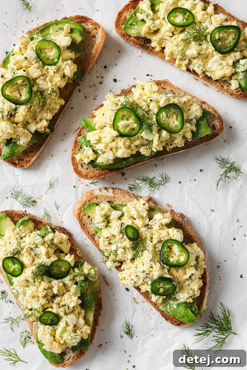 Cottage cheese egg salad served on crispy toast with fresh avocado and sliced jalapeno, ready to be enjoyed.