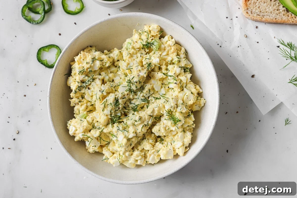 Creamy cottage cheese egg salad presented in a decorative serving bowl, garnished with fresh herbs.
