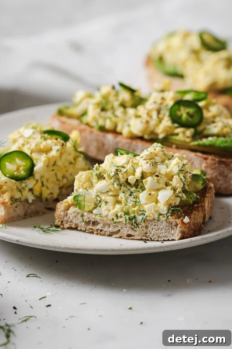 Close-up of cottage cheese egg salad served on toasted bread, sliced in half, showing its creamy texture and fresh herbs.
