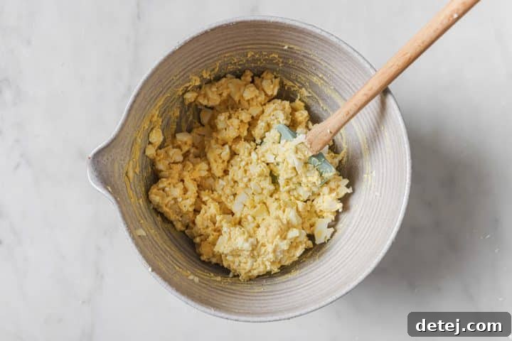 Cottage cheese egg salad base, a creamy mixture of egg yolks and seasonings, thoroughly combined in a bowl.
