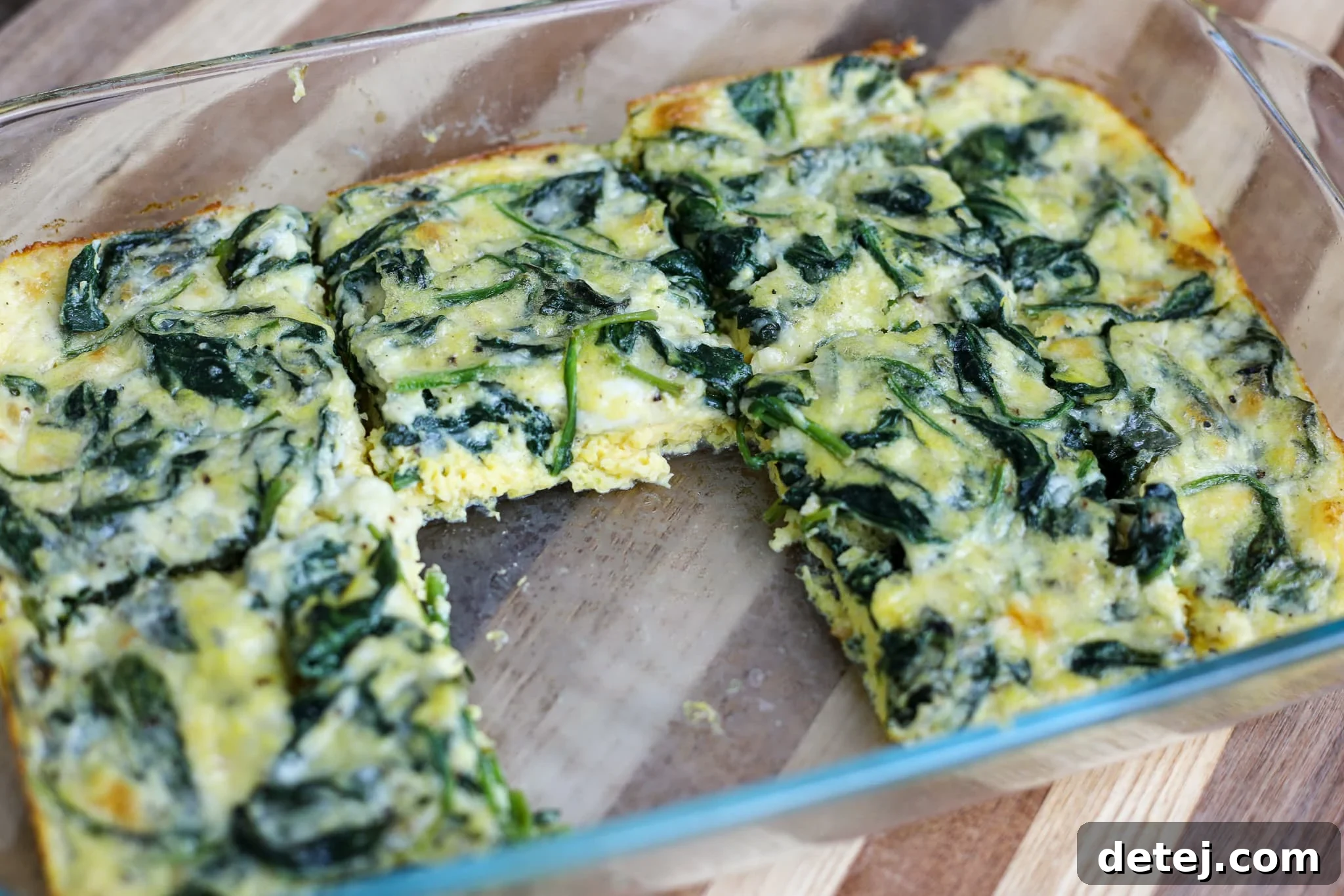 Savory Spinach and Cheesy Baked Eggs 2 Delicious and healthy Cheesy Spinach Baked Eggs in a baking dish, perfect for breakfast or brunch. A close-up shot showing the golden-brown edges and fluffy texture, garnished with fresh herbs.