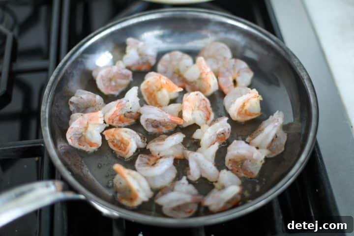 Egg Roll Stir-Fry Bowl 4 Shrimp sautéing in a hot pan, turning pink and opaque.