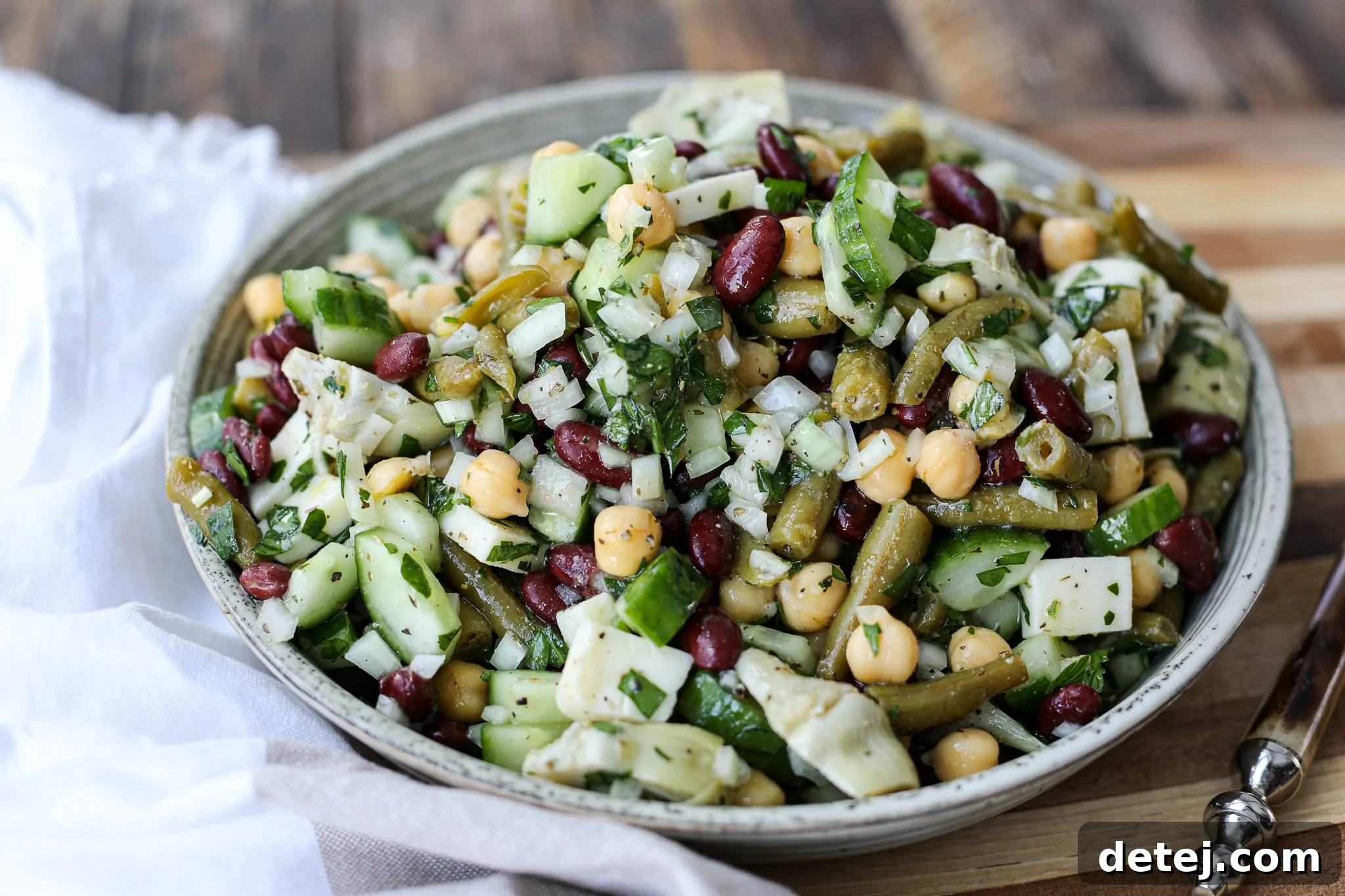 Vibrant Three Bean Salad in a clear glass bowl, ready to be served as a healthy appetizer or side dish.
