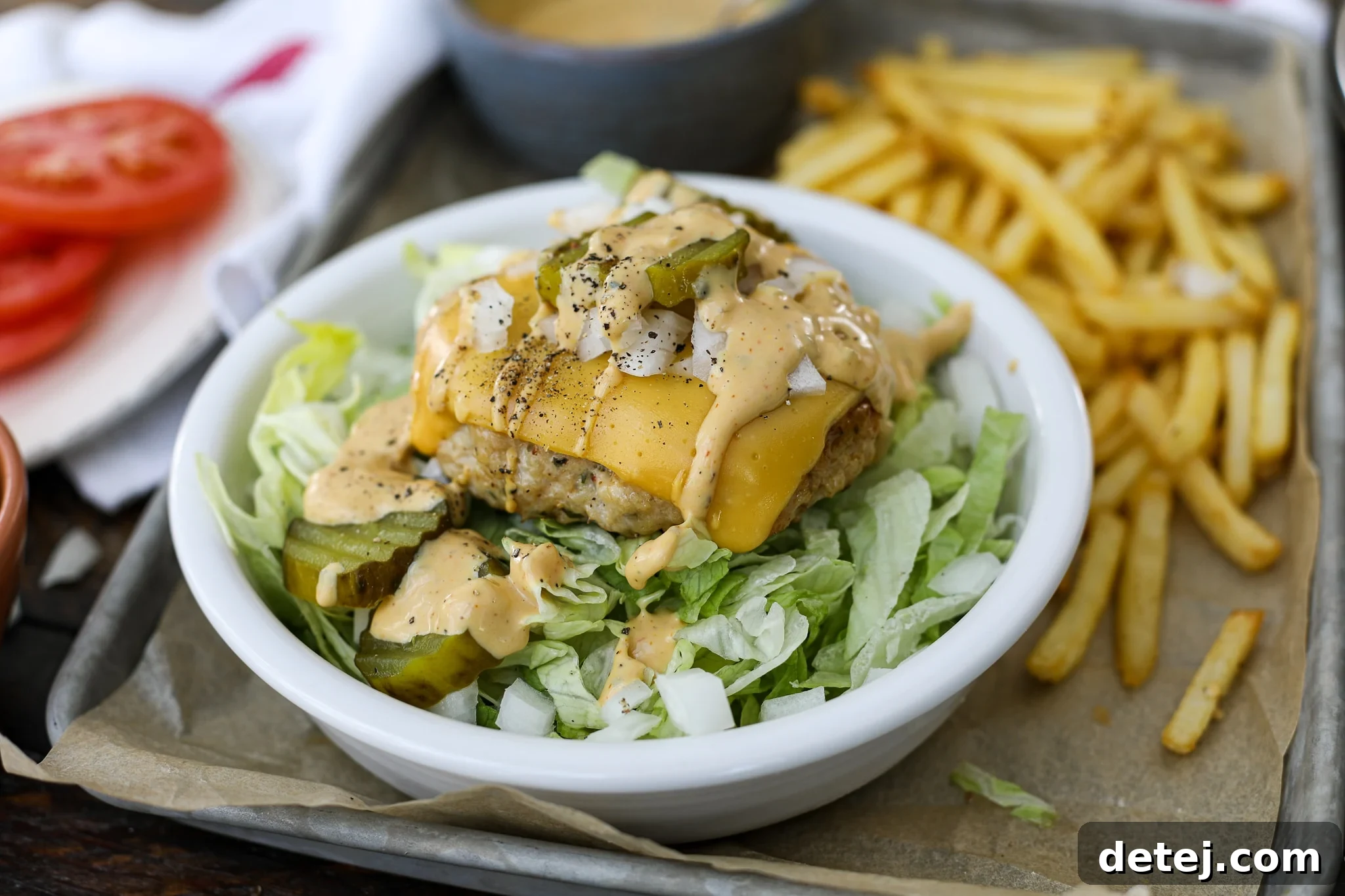 A vibrant Big Mac Style Chicken Burger Bowl, featuring a cheesy chicken patty, shredded lettuce, diced onions, and special sauce, showcasing a healthier alternative to the classic fast-food burger.