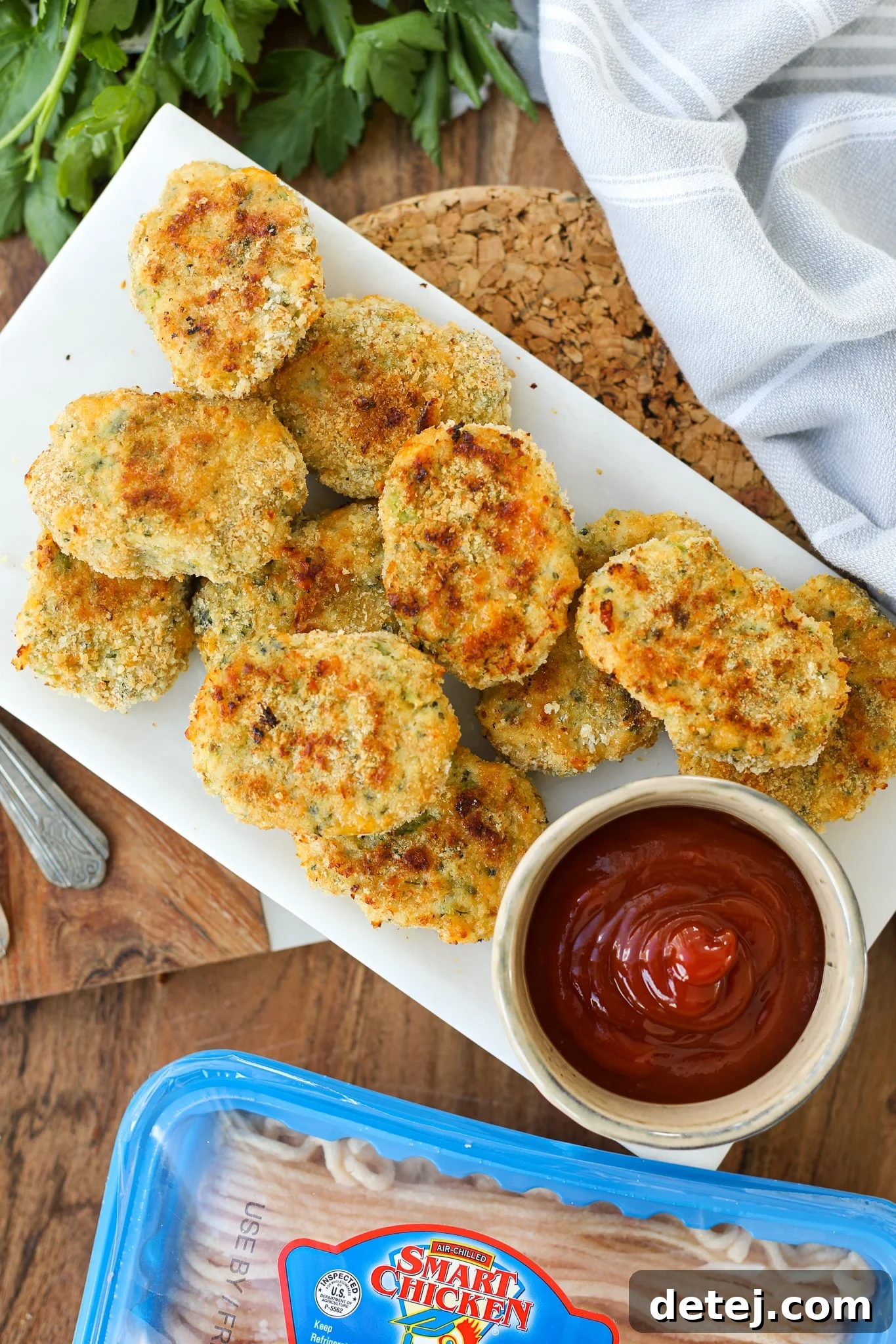 Closeup of Homemade Broccoli Cheddar Chicken Nuggets arranged on a baking sheet, ready to be served.