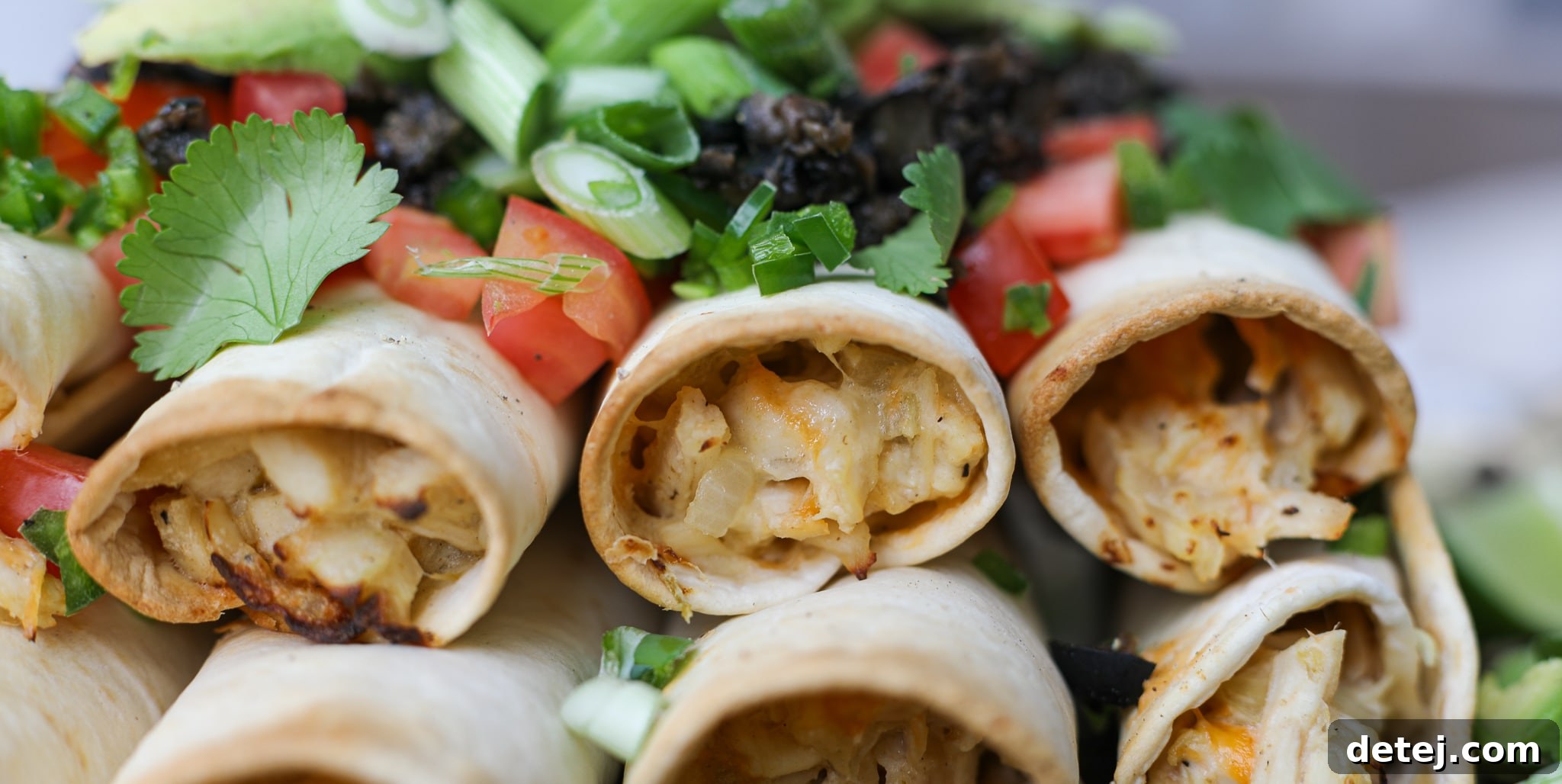 Bowl of chicken taquito filling mixture with shredded chicken, cheese, and vegetables