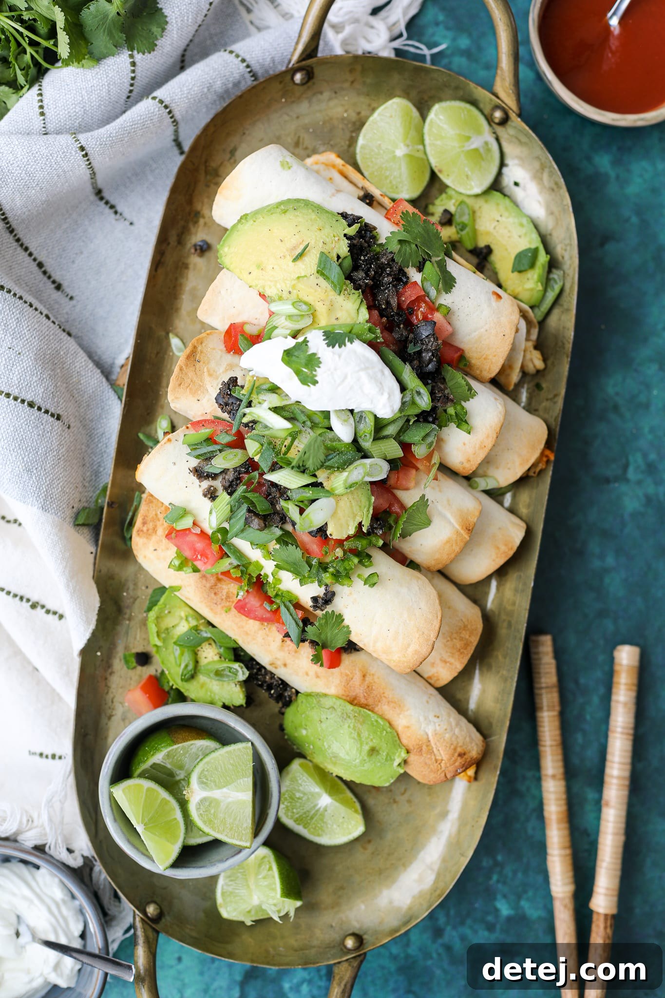 Air fryer basket filled with crispy chicken taquitos