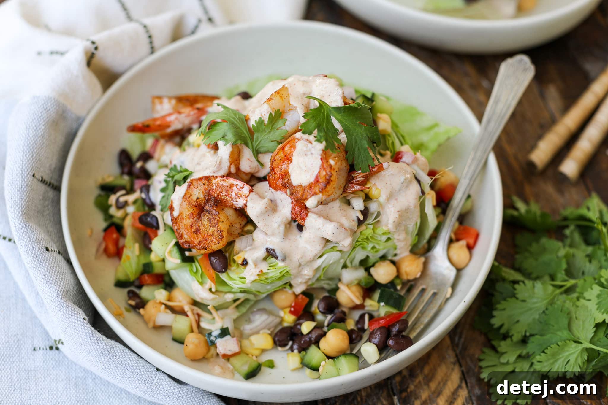 A beautifully assembled Blackened Shrimp Southwest Wedge Salad with a side of creamy dressing, ready to be enjoyed.