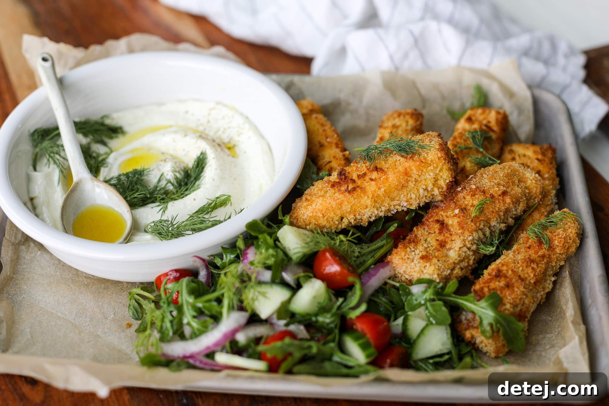 Breaded salmon fish sticks cooking in an air fryer basket, becoming golden brown and crispy.