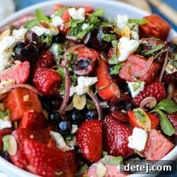 Vibrant Summer Refreshment 5 A vibrant Summer Fruit Salad featuring watermelon, strawberries, blueberries, raspberries, cherries, red onion, almonds, goat cheese, and mint, dressed with balsamic glaze and olive oil. Healthyish Foods.