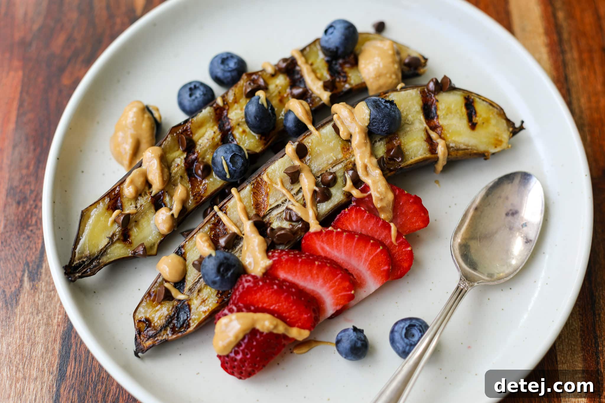 Delicious Healthyish Grilled Banana Split with melted chocolate, berries, and nut butter